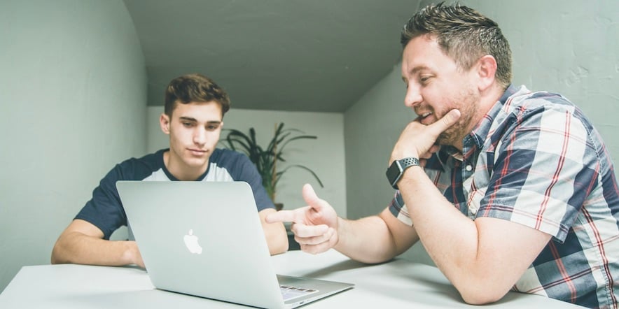 Two men at a laptop doing business